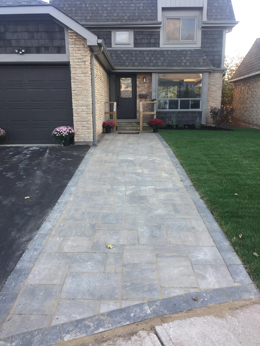Paver walkway with a contrasting border leading to a stone-fronted entrance